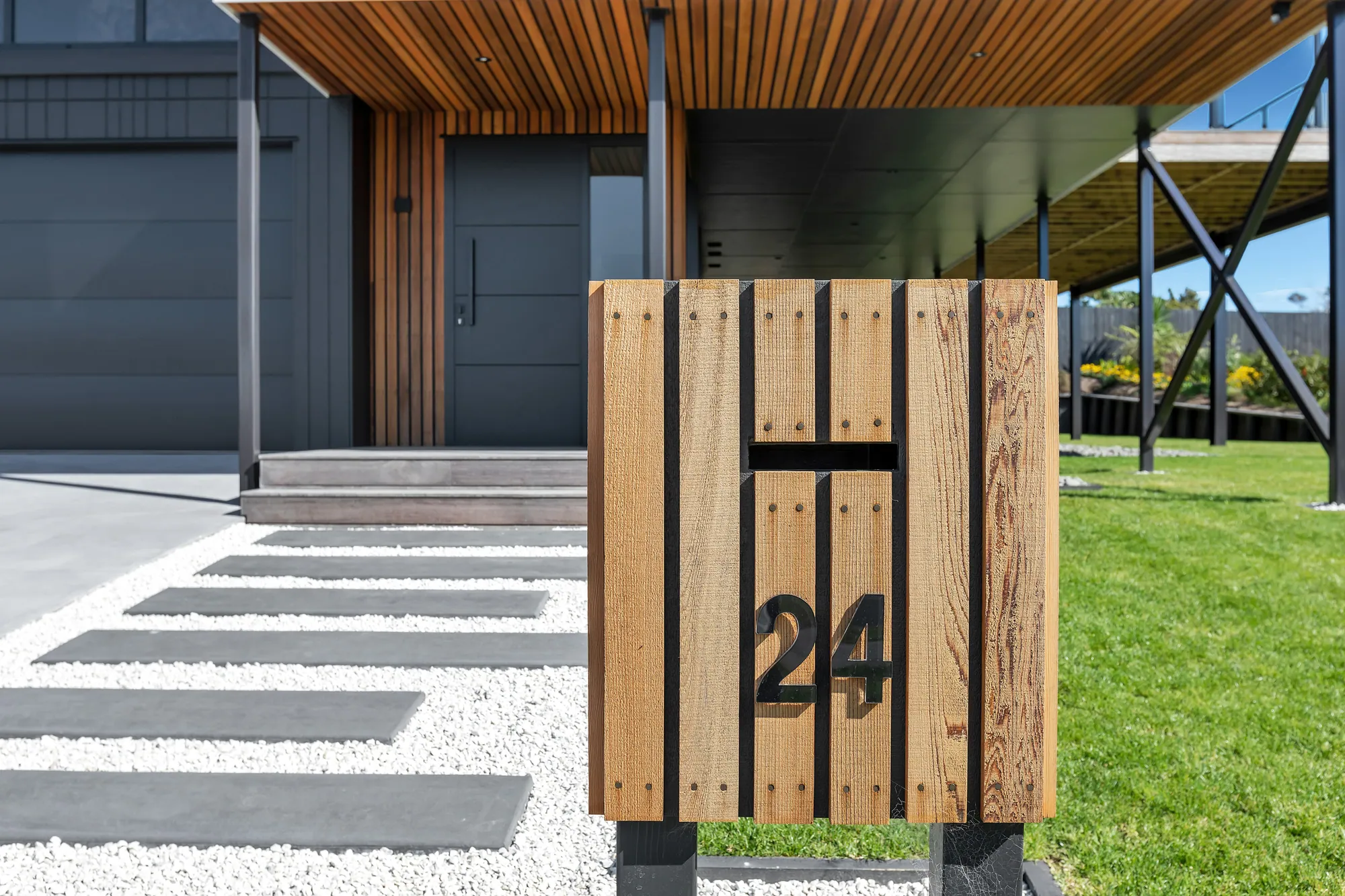 Timber entry gate and planted approach to a Cogan-built home, Marsden Cove