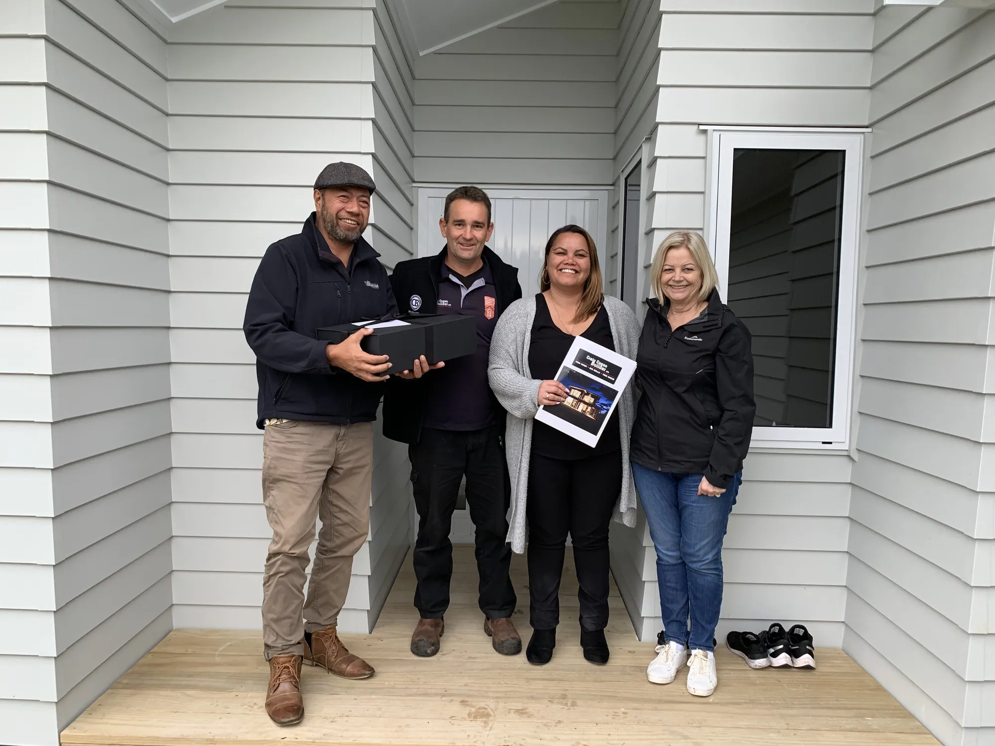 Craig with clients at the front door of their new home