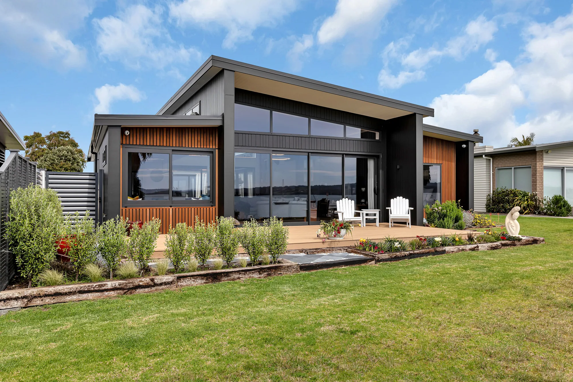 Architecturally designed home with an angled roof, cedar and dark cladding