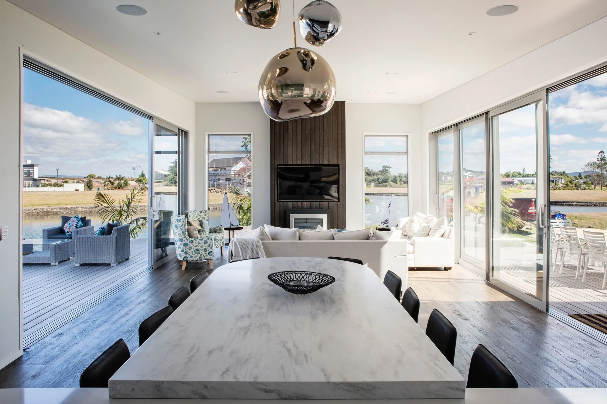 Marble dining table in an open-plan living room with sliding doors to the deck