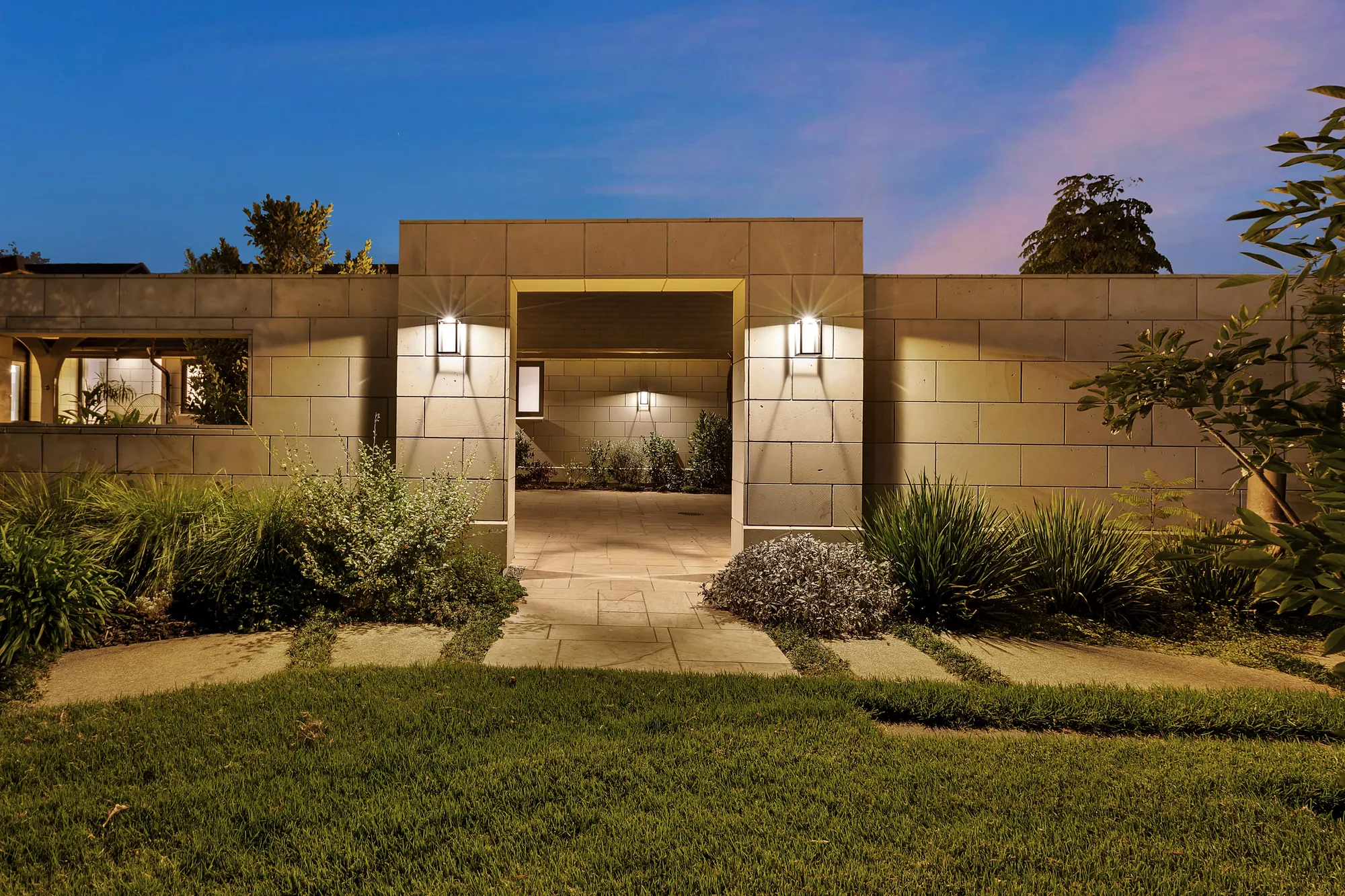 The Cogan waterfront showhome at dusk, lit from within