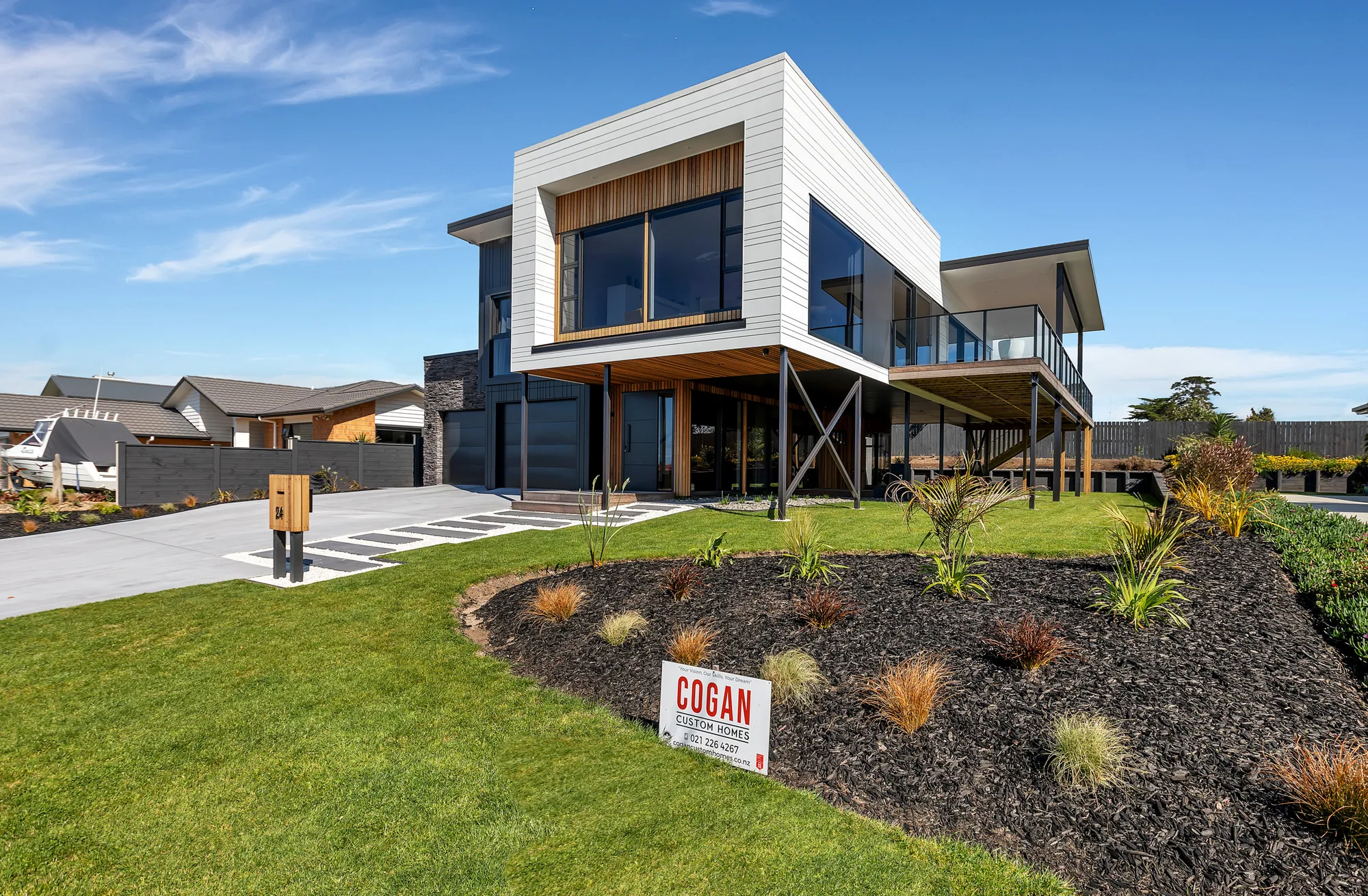 Two-storey home with a white upper level cantilevered over the entry