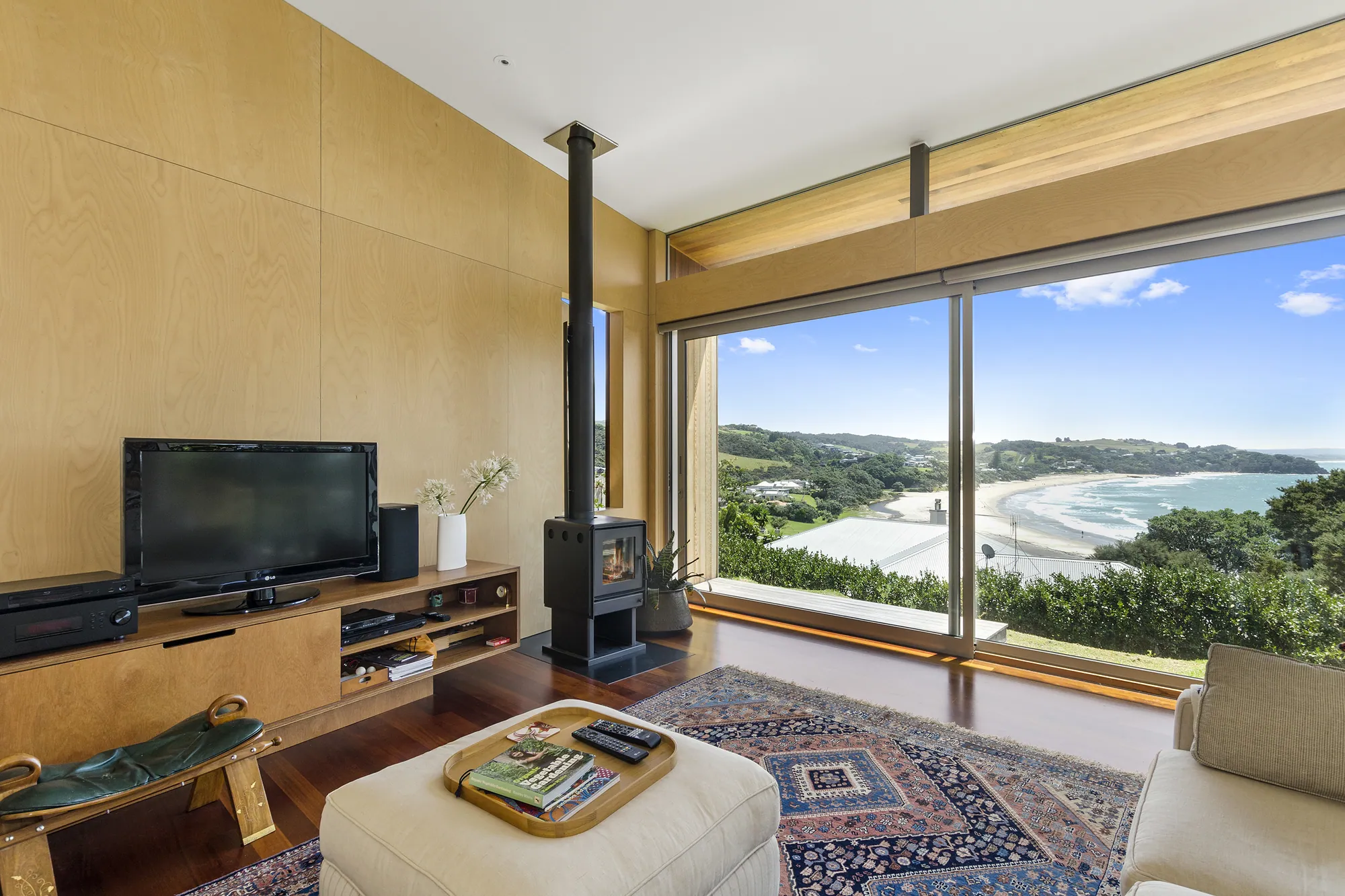 Living room with a wood burner and a view down to the beach