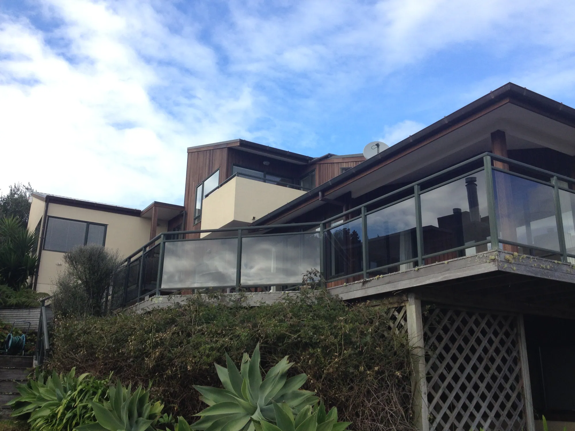 The hillside home before recladding, in cedar and plaster with the original timber deck