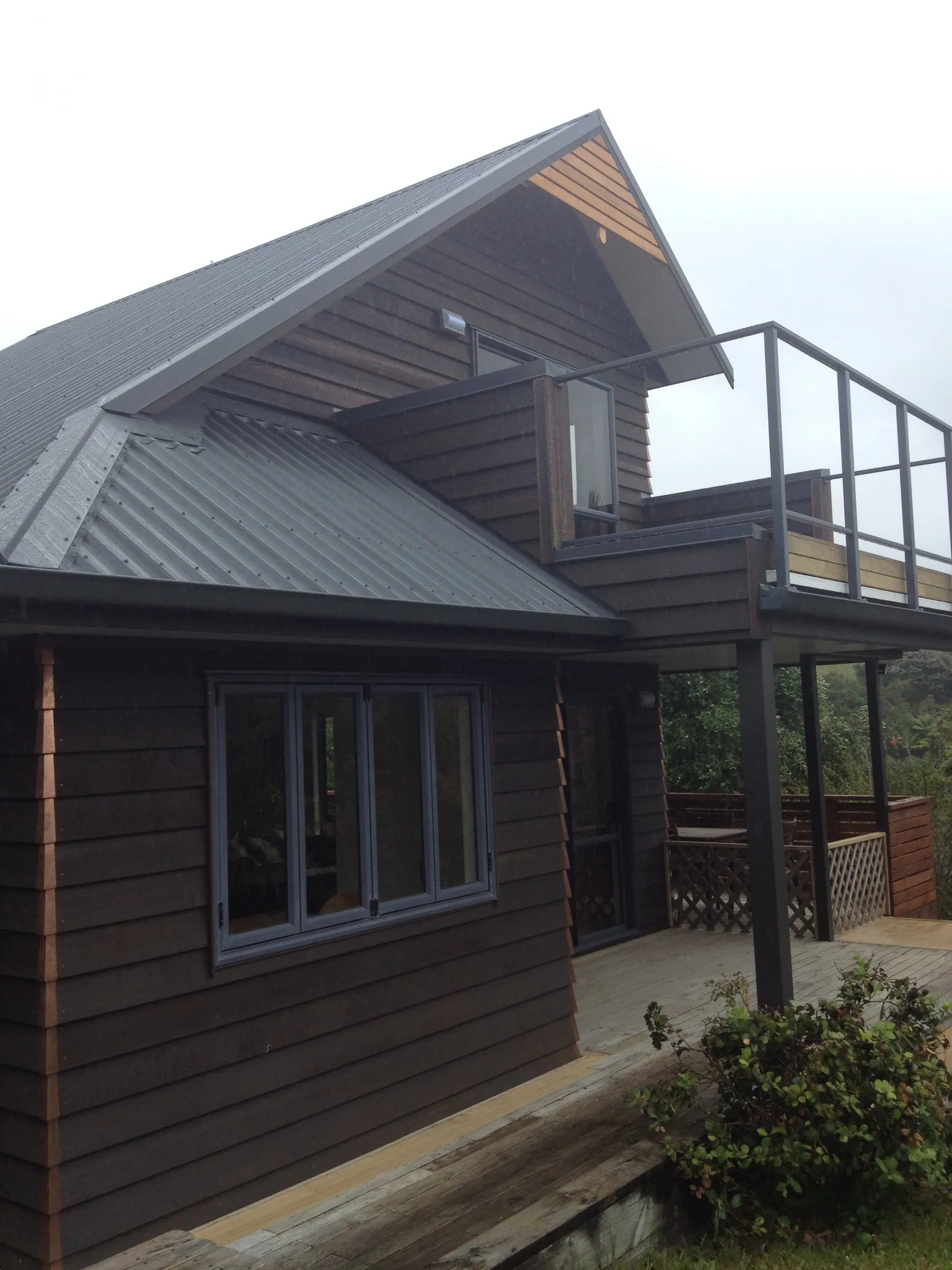 Completed Cogan recladding project in dark-stained weatherboard, with a rebuilt upper deck