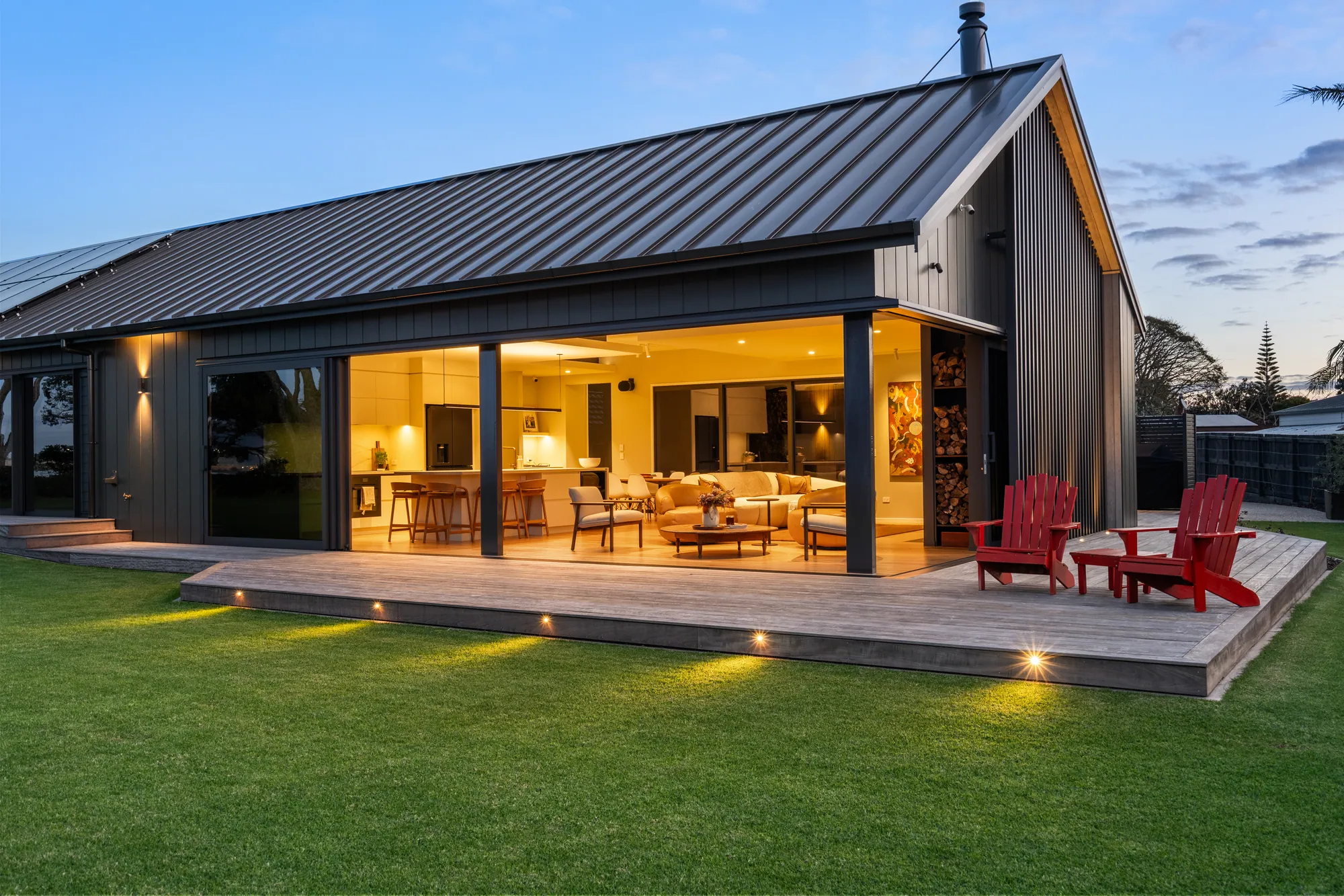 The showhome deck at dusk with the interior lit