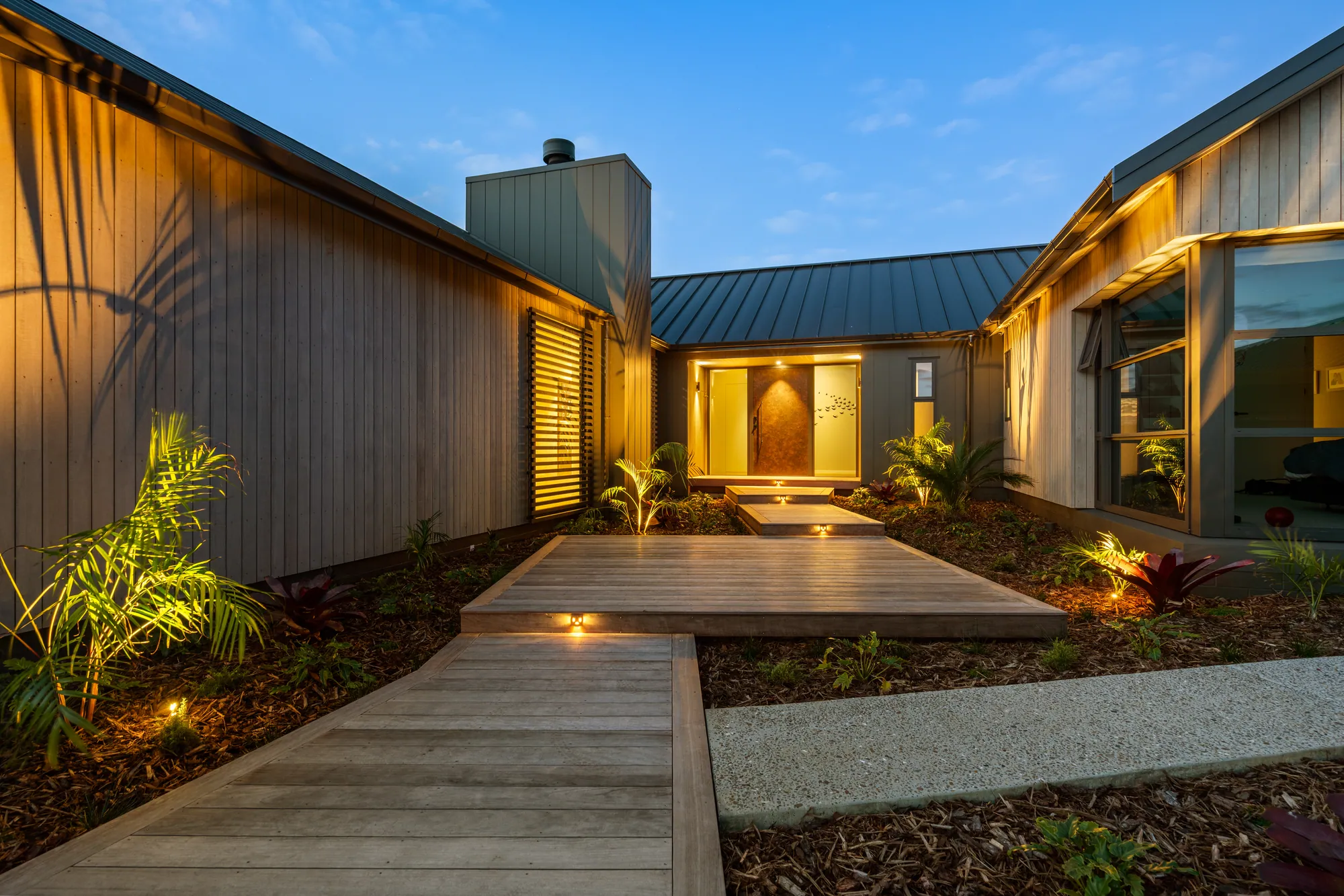 The lit entry court of the showhome at dusk