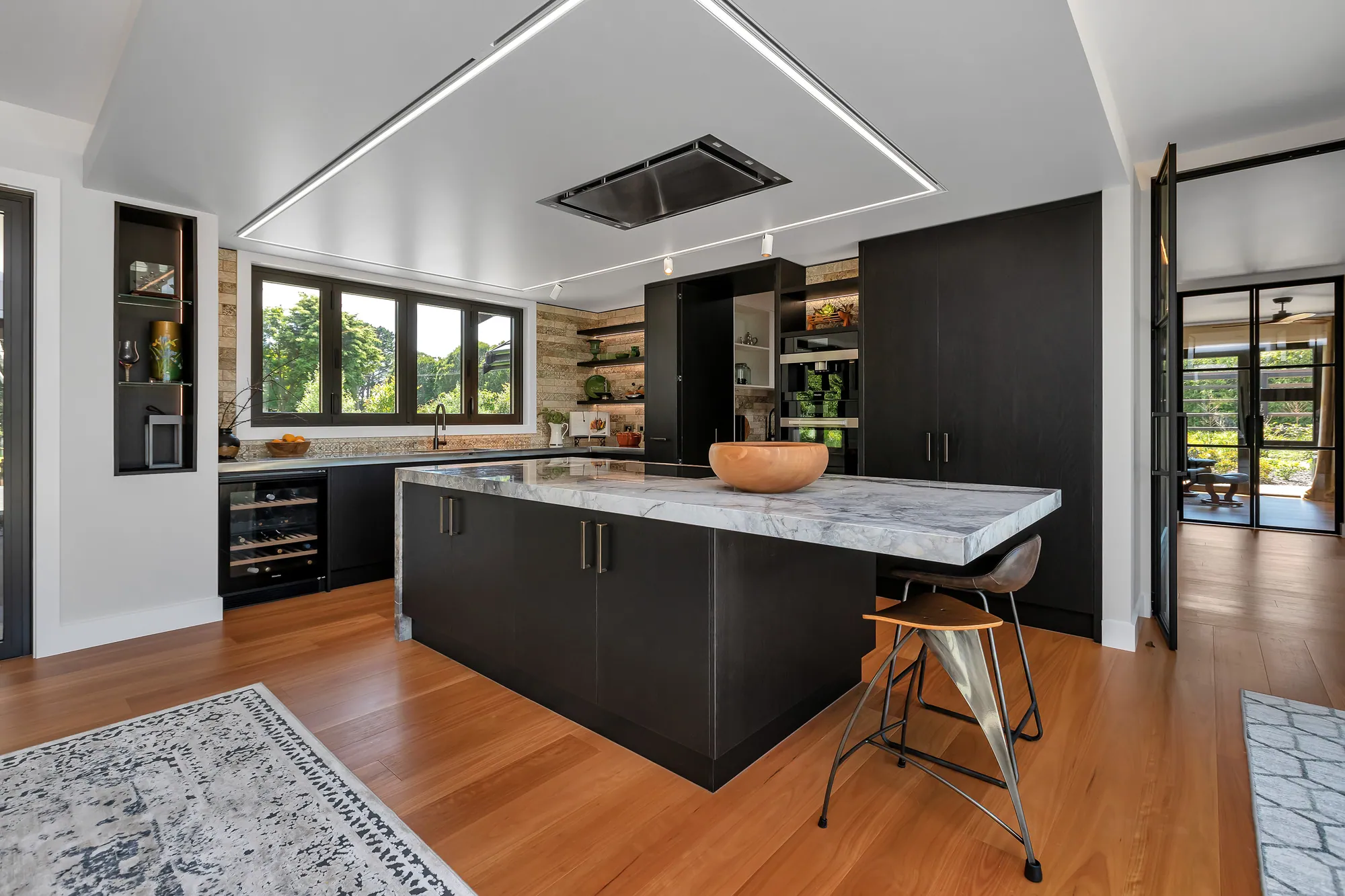Dark kitchen joinery with stone island in a Waipu home